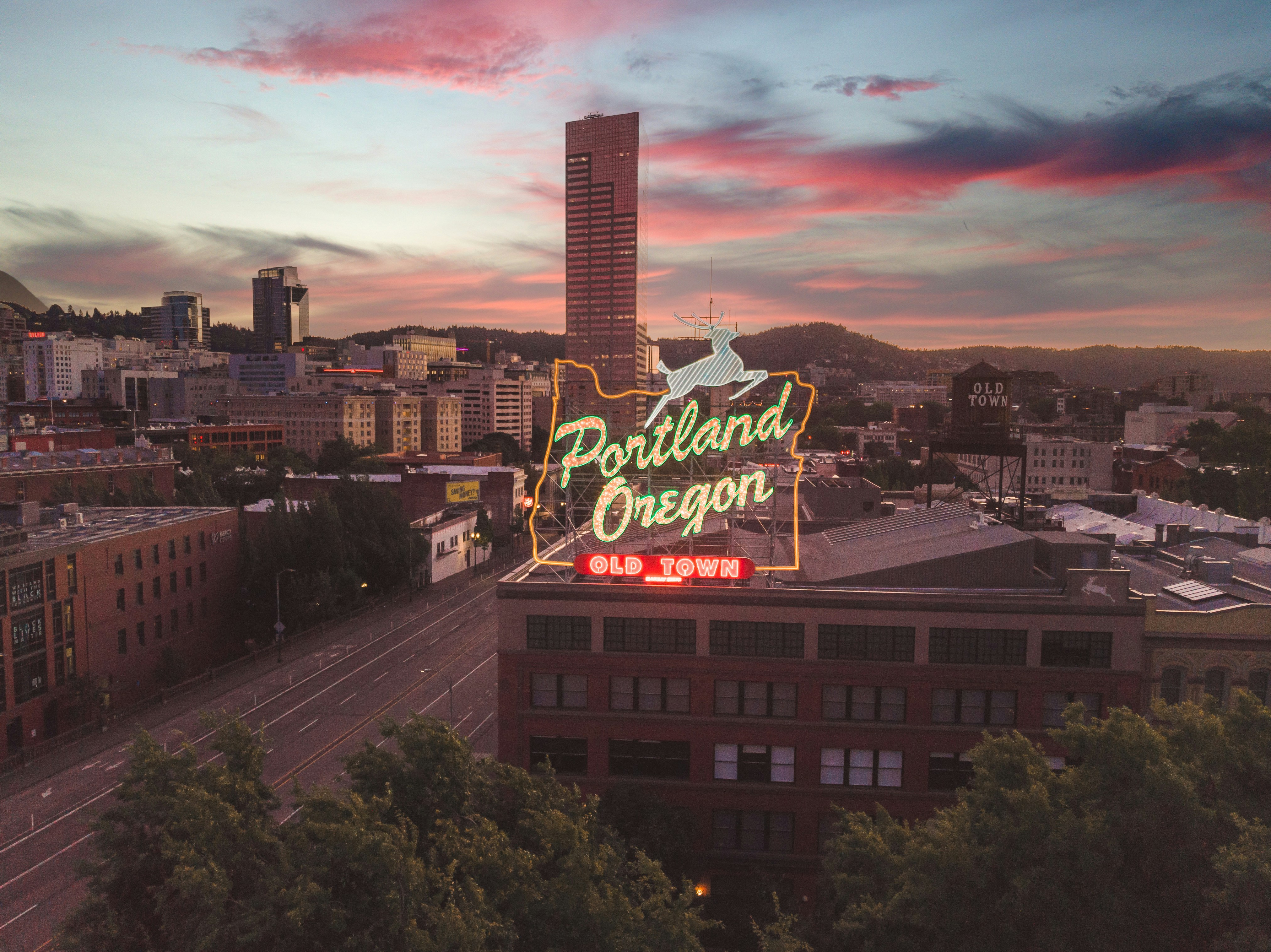 Portland Oregon neon sign glowing above Old Town at dusk
